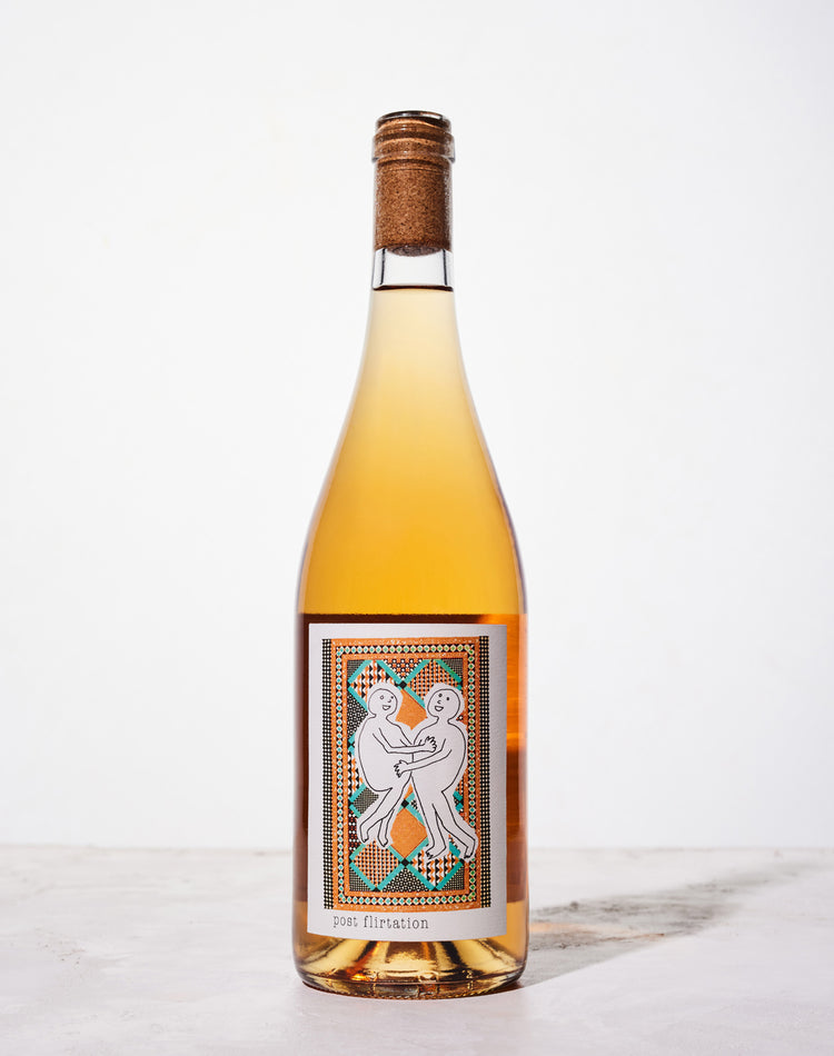 A bottle of rosé wine with a cork top, featuring a label with two abstract figures dancing on a patterned background.