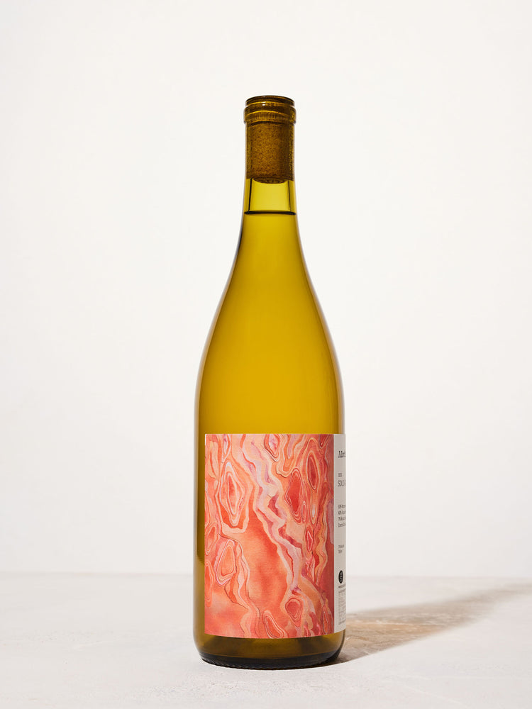 A wine bottle with a cork, featuring a vibrant label with swirled pink and red marble patterns. The bottle is set against a neutral background.