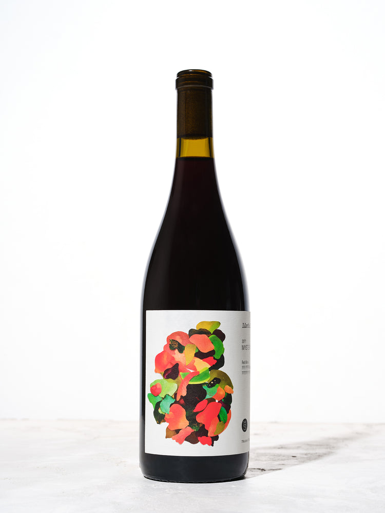 A wine bottle with a colorful label shot against a white background
