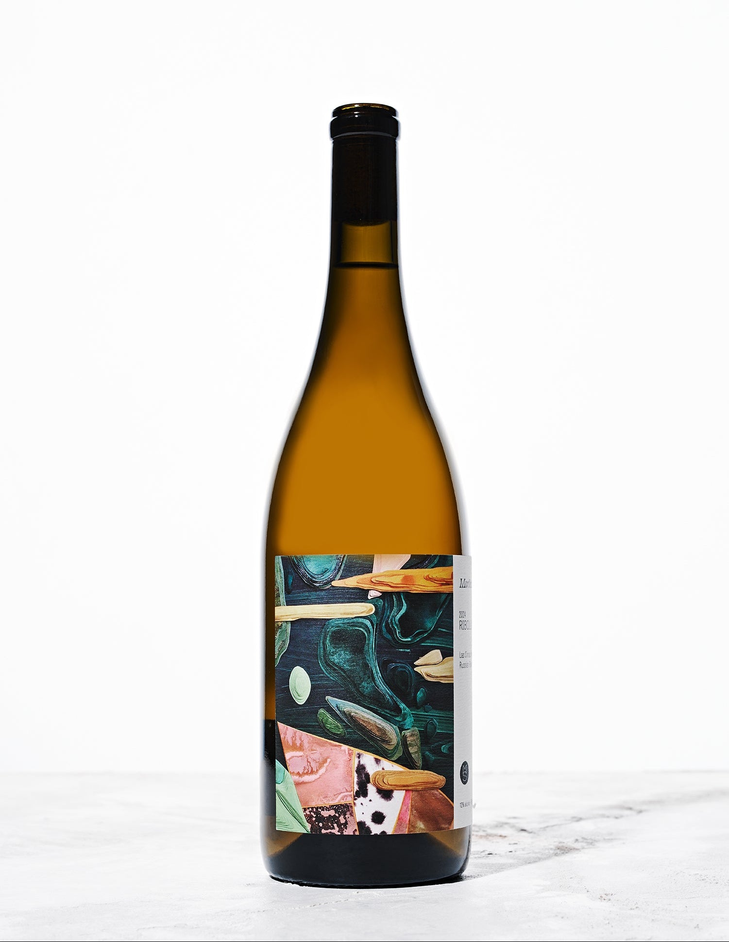 A brown wine bottle sits on a white background. The label features teal, pink, and orange cut outs in a collage pattern.