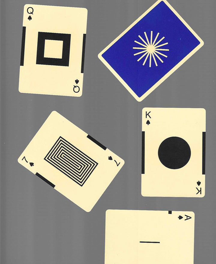 A set of five uniquely designed playing cards are scattered. Each has a distinct geometric pattern on a cream background. The background is gray.
