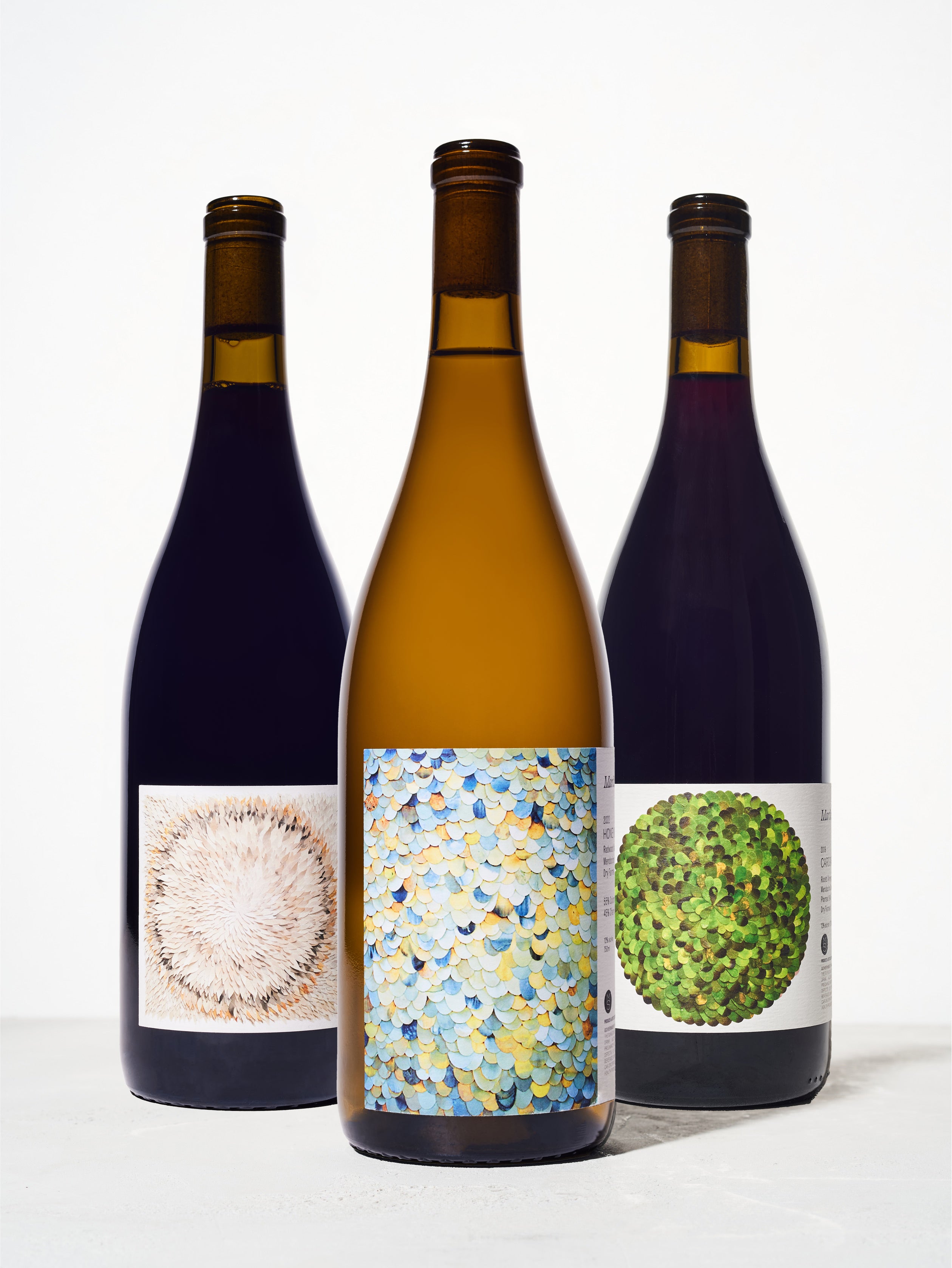 Three bottles of assorted wine against a white background.